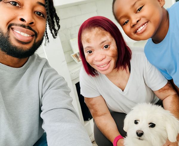 Monyette with a man, a child, and her Yorkie dog, Leo — all smiling