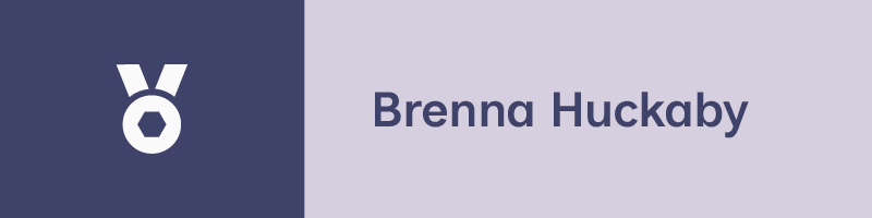A two-tone graphic with an icon featuring the sports medallion in white against a dark blue background on the left side, and the name "Brenna Huckaby" in blue against a light purple background on the right side.