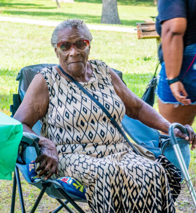Eldery African American woman sitting in a chair outside at a park